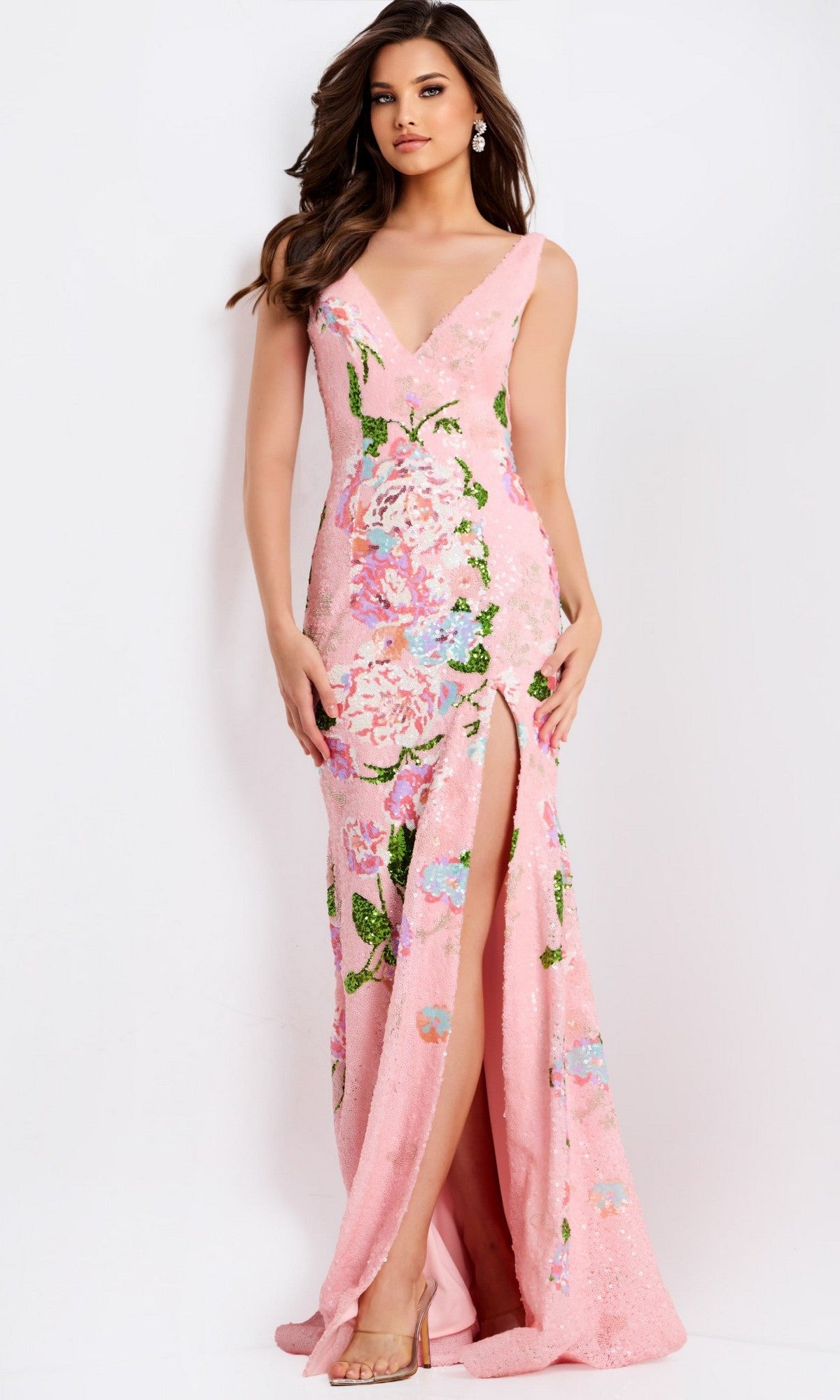 A woman wearing the Jovani 48636 long prom dress, sleeveless and light pink with beaded floral designs and a thigh-high slit, stands against a plain white background.